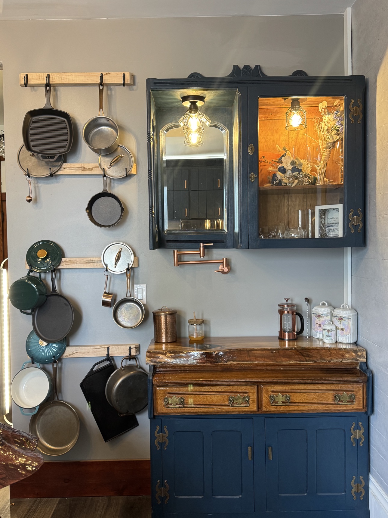 Kitchen coffee bar nook with hanging pot rack and navy hutch