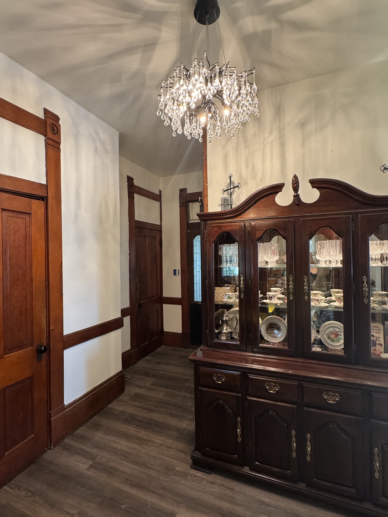 Renovated dining room with chandelier and china hutch, designed and built by New Life General Contracting