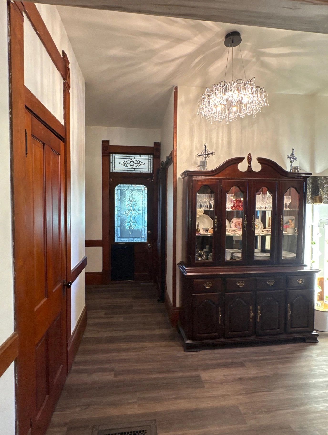 Restored 1800s hallway with leaded glass transom over the back door and original woodwork