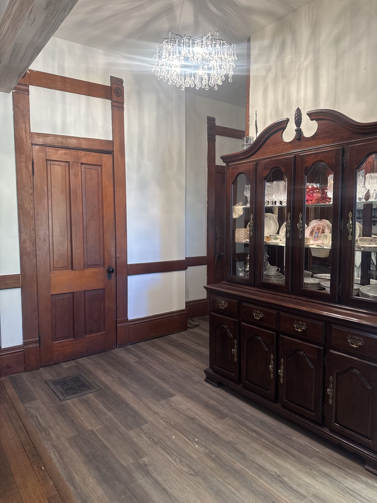 Restored hallway with original wood doors, trim, and wainscoting preserved