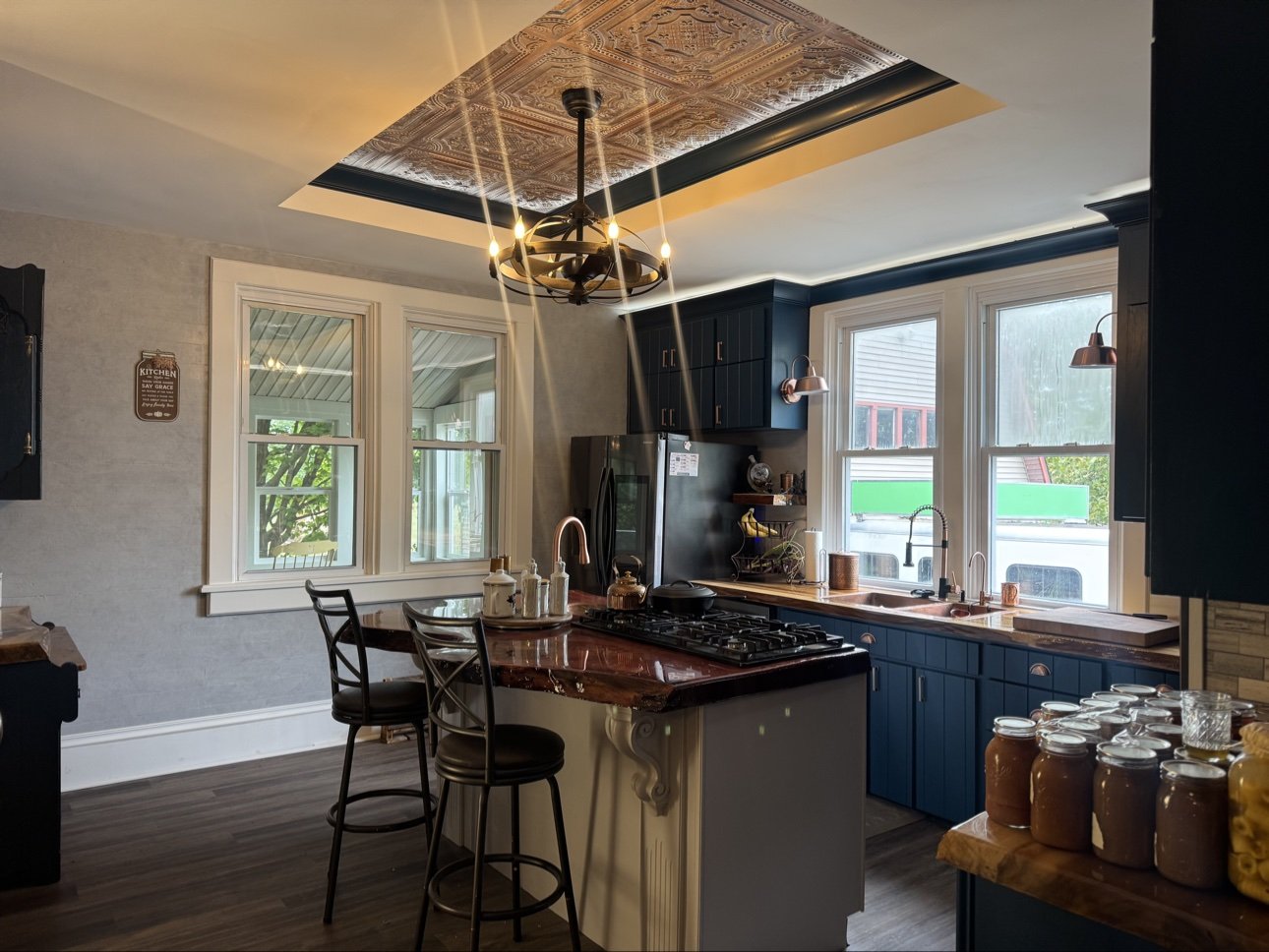 Victorian kitchen after remodeling in Indianapolis — navy cabinets, copper tin ceiling, and a live-edge island